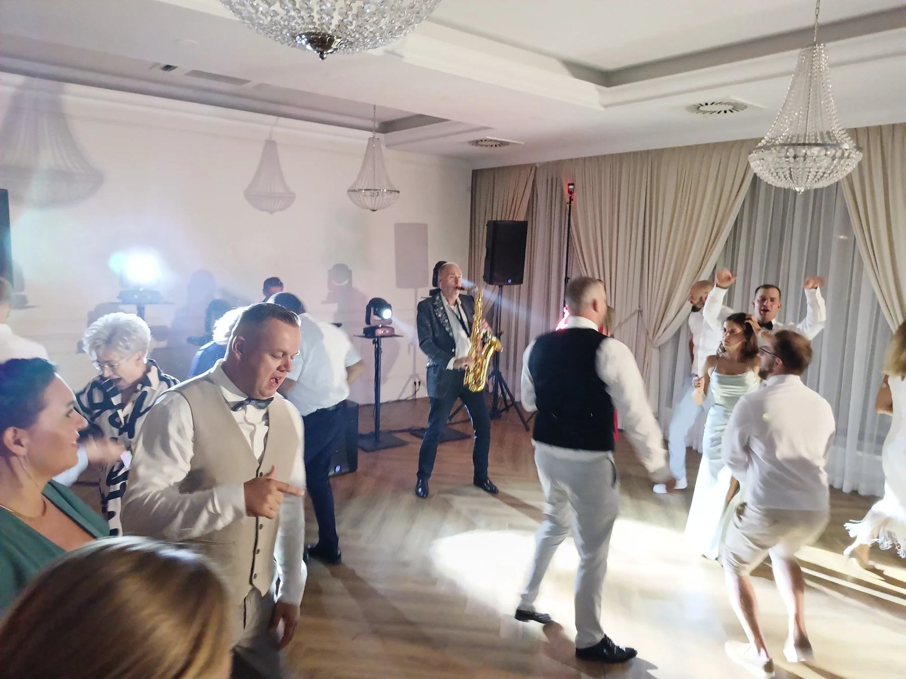 Goście tańczą podczas występu Sebastiana na saksofonie